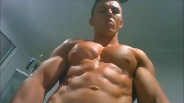 young muscle hunk posing and flexing at home with huge chest